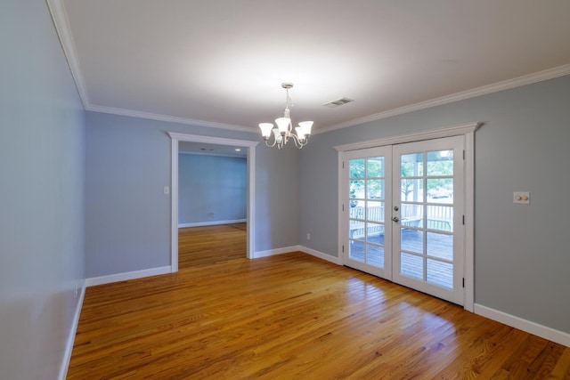 empty room featuring light wood-type flooring, french doors, an inviting chandelier, and ornamental molding