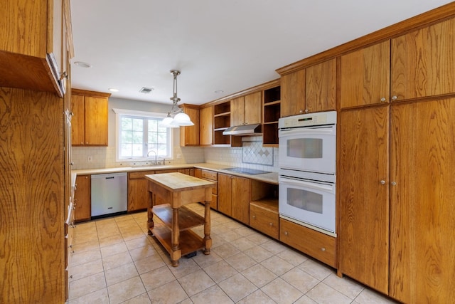 kitchen featuring stainless steel dishwasher, backsplash, white double oven, and hanging light fixtures