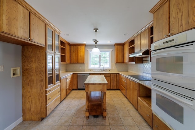 kitchen with dishwasher, a center island, pendant lighting, black electric stovetop, and decorative backsplash