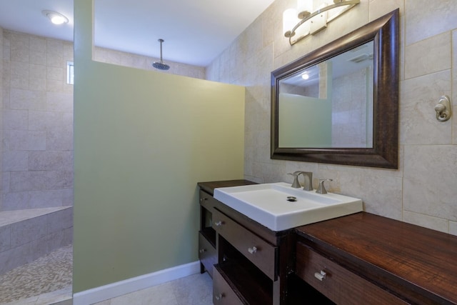 bathroom featuring vanity, tile walls, walk in shower, and tile patterned flooring