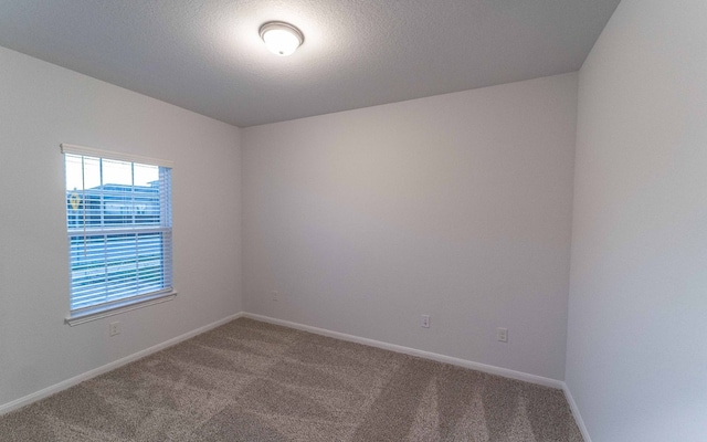 carpeted spare room with a textured ceiling