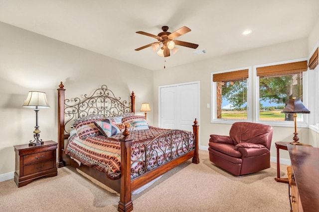 carpeted bedroom featuring ceiling fan and a closet