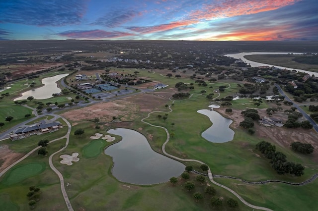 aerial view at dusk featuring a water view