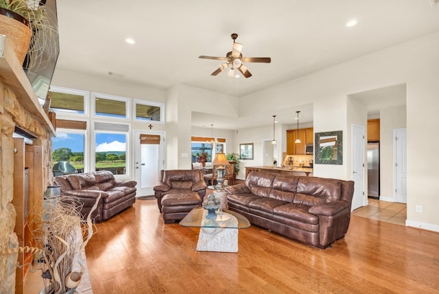 living room with light wood-type flooring and ceiling fan