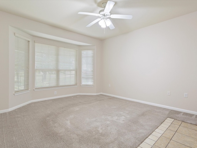 unfurnished room with light colored carpet and ceiling fan