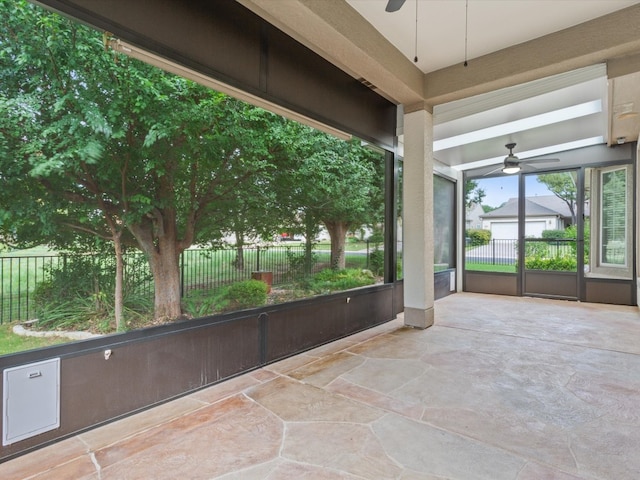 unfurnished sunroom featuring ceiling fan