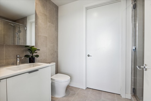 bathroom with vanity, toilet, a shower, and tile patterned flooring