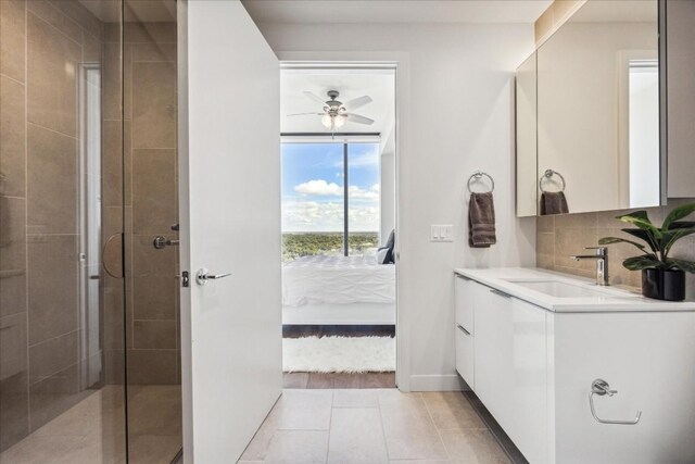 bathroom with vanity, a shower with shower door, ceiling fan, and tile patterned flooring