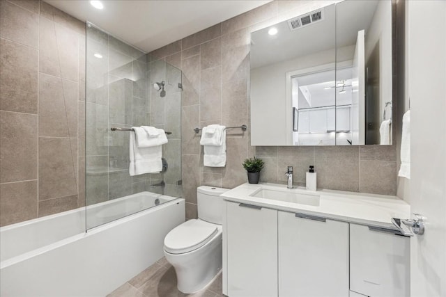 44 E Ave Unit 1709, Austin, TX 78701 - full bathroom with toilet, tile walls, vanity, bathing tub / shower combination, and recessed lighting