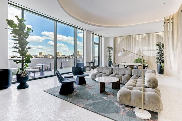 carpeted living room featuring floor to ceiling windows and a healthy amount of sunlight