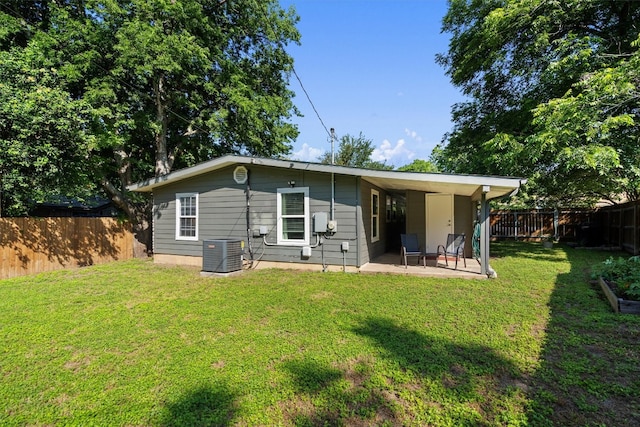 rear view of property featuring a yard, a patio area, and central air condition unit