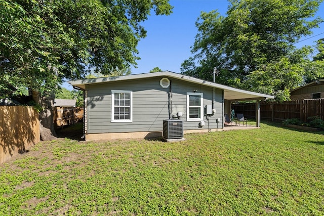 rear view of property with central AC, a yard, and a patio area