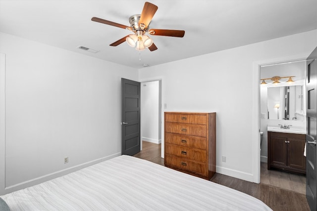 bedroom featuring dark wood-type flooring, sink, ensuite bathroom, and ceiling fan