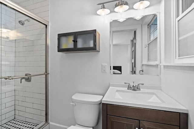 bathroom featuring walk in shower, toilet, and vanity