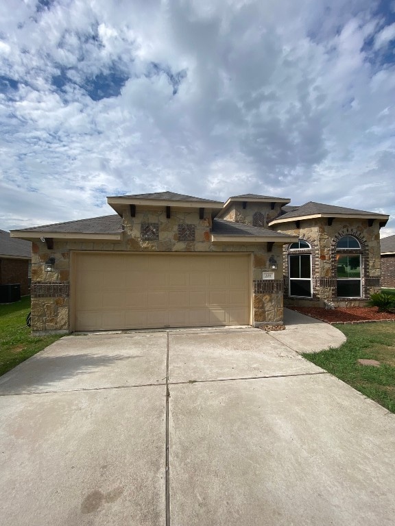 view of front of property with a garage and central AC