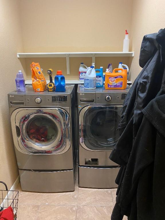 laundry room featuring tile patterned floors, laundry area, and separate washer and dryer