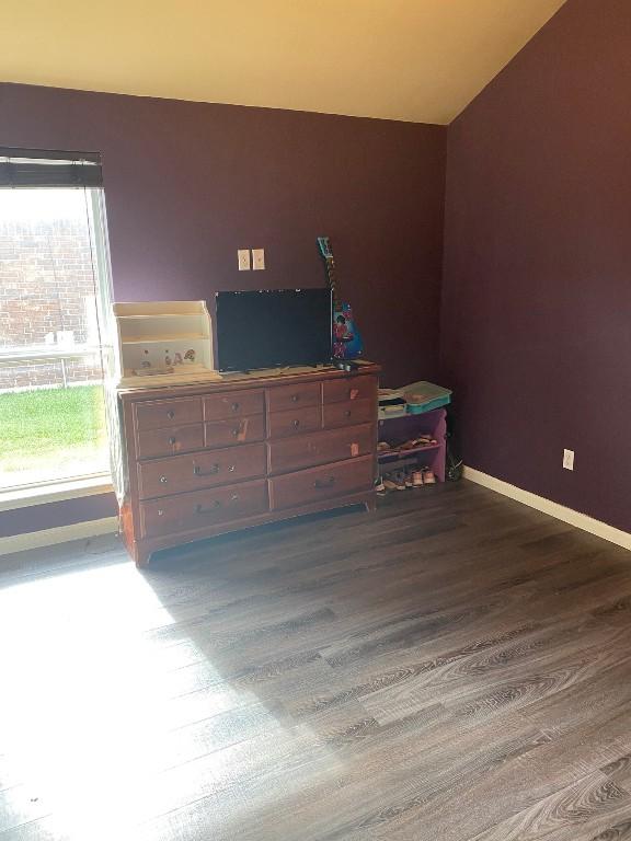 bedroom with baseboards and wood finished floors