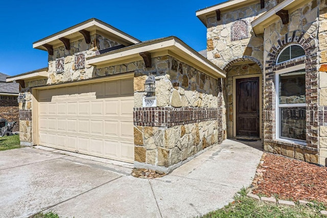 206 Swenson Dr, Hutto, TX 78634 - property entrance with stone siding, concrete driveway, and an attached garage