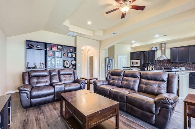 206 Swenson Dr, Hutto, TX 78634 - living area with ceiling fan, arched walkways, dark wood finished floors, a raised ceiling, and recessed lighting