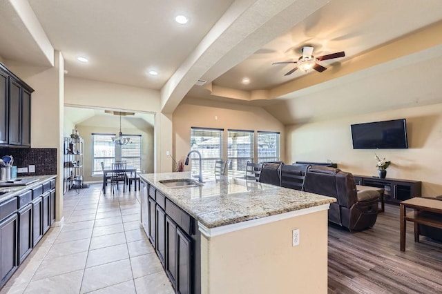 206 Swenson Dr, Hutto, TX 78634 - kitchen featuring backsplash, light stone counters, a chandelier, open floor plan, and ceiling fan