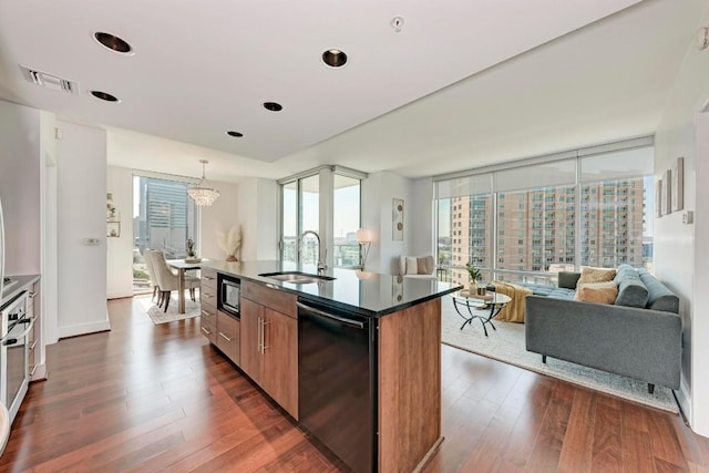 kitchen with visible vents, dark wood-type flooring, black appliances, floor to ceiling windows, and a sink