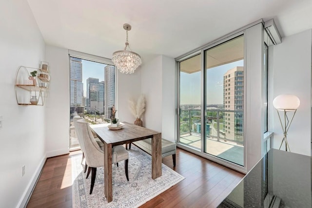 dining area featuring expansive windows, a healthy amount of sunlight, wood finished floors, and a city view