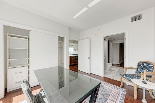 dining area with wood finished floors, visible vents, and baseboards