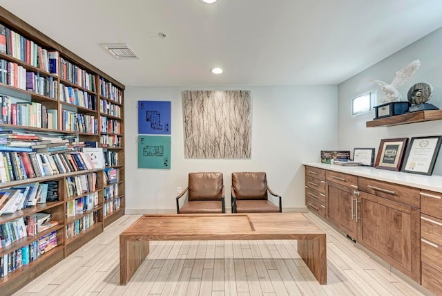 living area with light wood-type flooring, baseboards, and visible vents