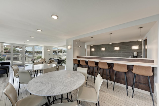 dining room featuring a wall of windows, recessed lighting, and light wood finished floors