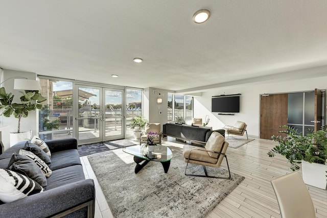 living area with a wall of windows, recessed lighting, french doors, and wood finished floors