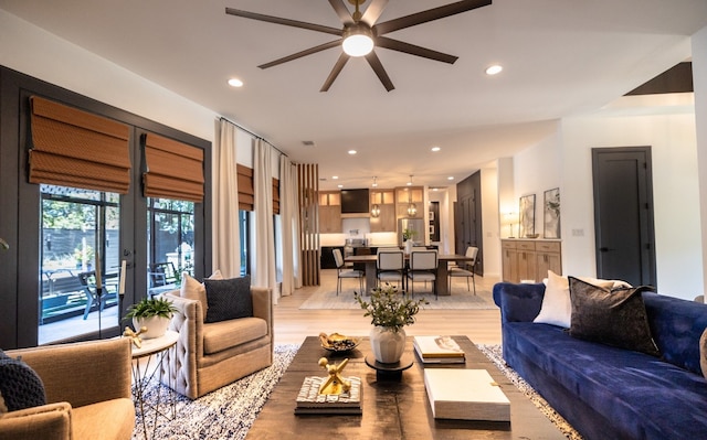 living room featuring light wood-type flooring and ceiling fan