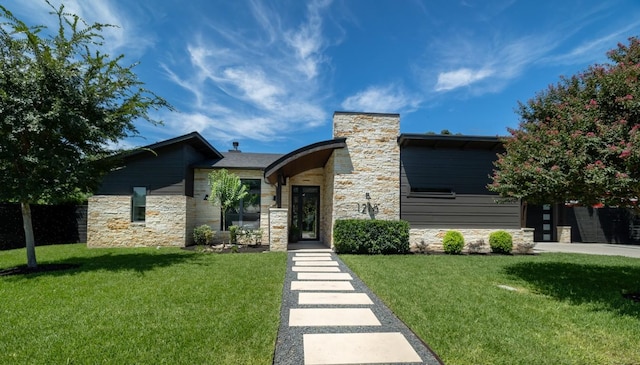 view of front of property with stone siding, a front lawn, and a chimney