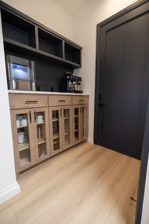 bar with light wood-type flooring and baseboards