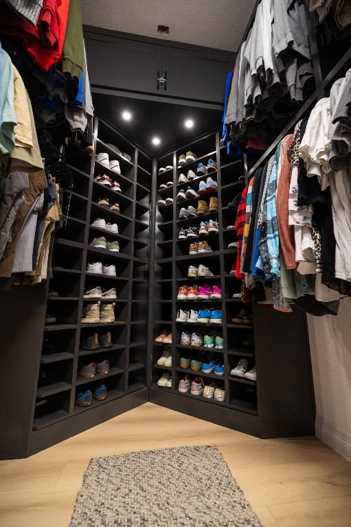 walk in closet with wood finished floors