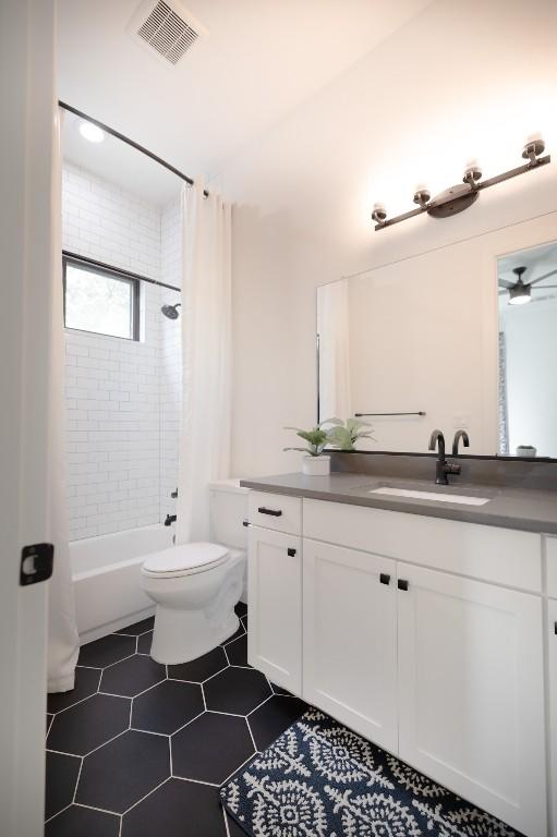 bathroom with shower / tub combo with curtain, visible vents, toilet, vanity, and tile patterned floors