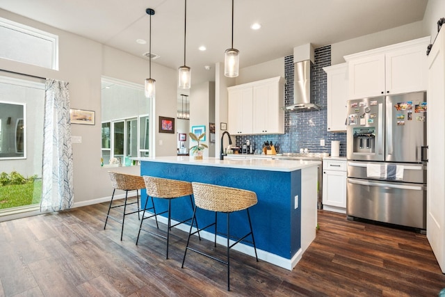 103 Hans Bell Dr, Blanco, TX 78606 - kitchen with stainless steel refrigerator with ice dispenser, wall chimney exhaust hood, dark wood-style flooring, decorative backsplash, and a center island with sink
