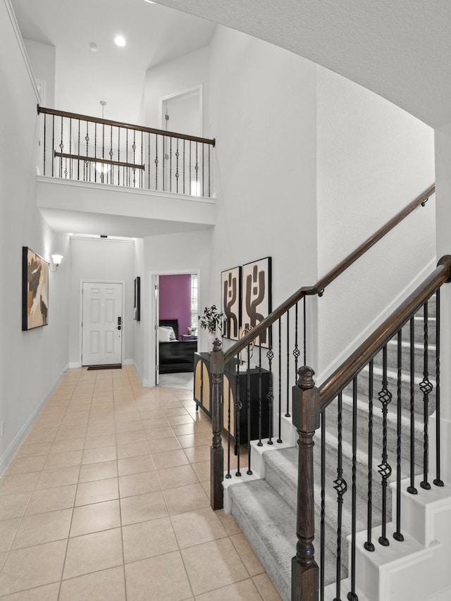 foyer entrance featuring light tile patterned floors and a high ceiling