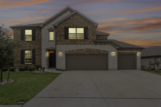 view of front of property with a yard and a garage