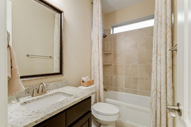 bathroom featuring toilet, shower / bath combo with shower curtain, and vanity