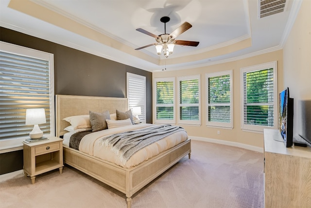 bedroom featuring light carpet, visible vents, baseboards, a raised ceiling, and crown molding