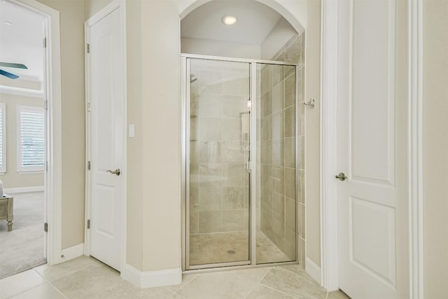 full bathroom featuring tile patterned flooring, a shower stall, and baseboards