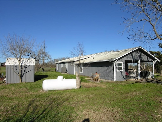 back of property with a storage unit and a lawn