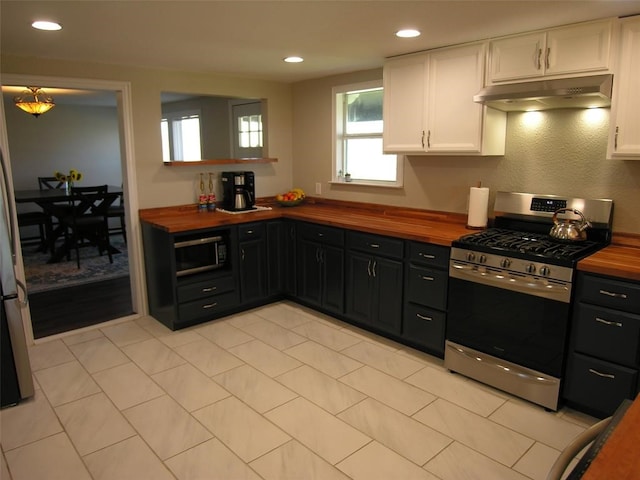 kitchen with appliances with stainless steel finishes, wood counters, and white cabinets