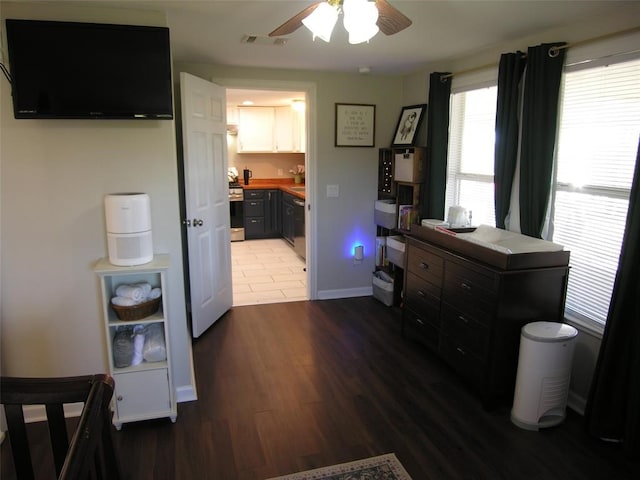 interior space with hardwood / wood-style floors, ensuite bathroom, and ceiling fan