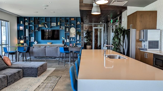 222 W Ave Unit 1503, Austin, TX 78701 - kitchen with a sink, built in microwave, freestanding refrigerator, open floor plan, and concrete flooring