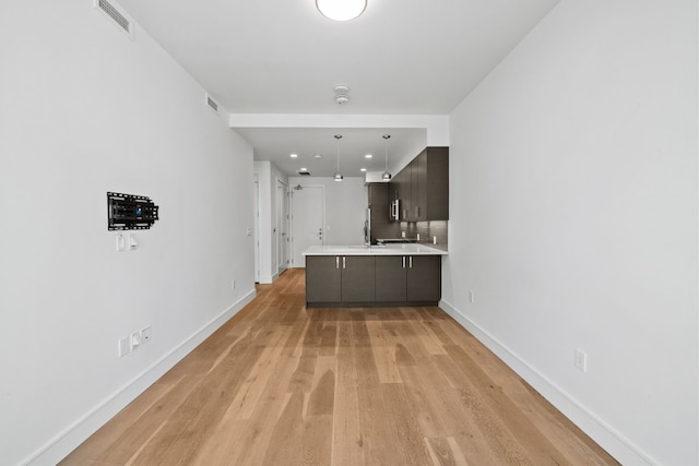 222 W Ave Unit 1503, Austin, TX 78701 - kitchen featuring baseboards, a peninsula, light countertops, light wood-style flooring, and recessed lighting