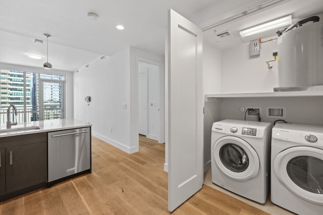 washroom with light wood-type flooring, sink, and separate washer and dryer