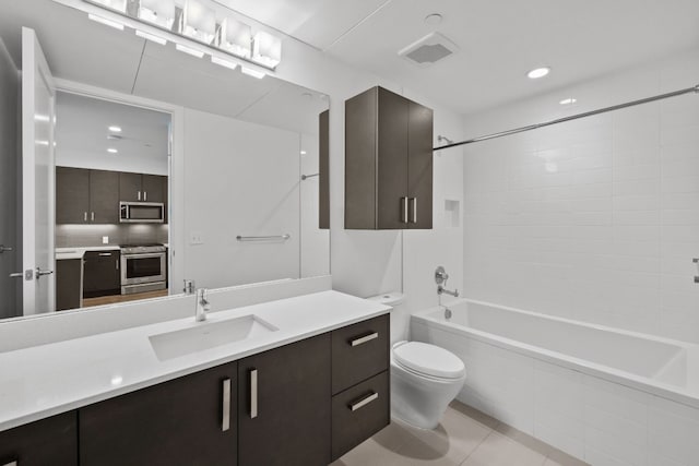 full bathroom featuring toilet, vanity, tile patterned floors, and tiled shower / bath combo