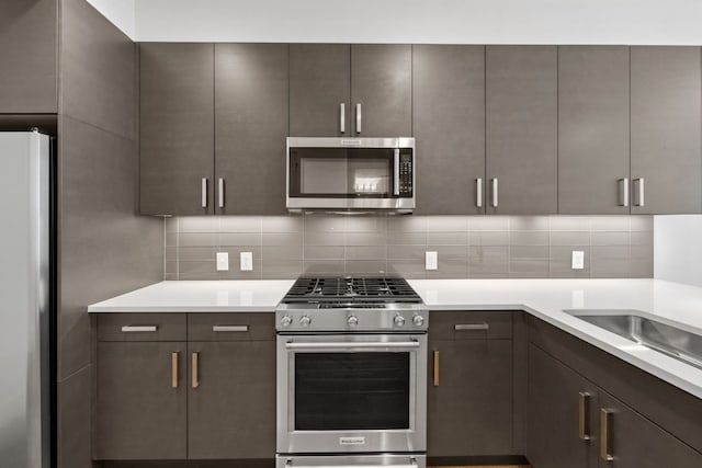 222 W Ave Unit 1503, Austin, TX 78701 - kitchen with stainless steel appliances, light countertops, decorative backsplash, and dark brown cabinetry