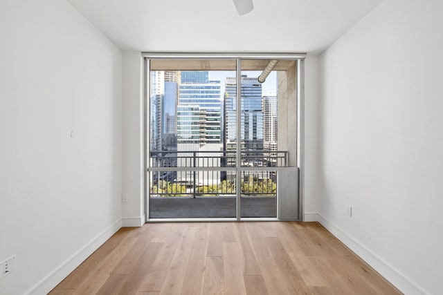 spare room with light hardwood / wood-style floors and floor to ceiling windows